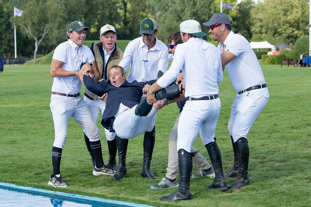Robert Whitaker is thrown into the water jump by a group of riders