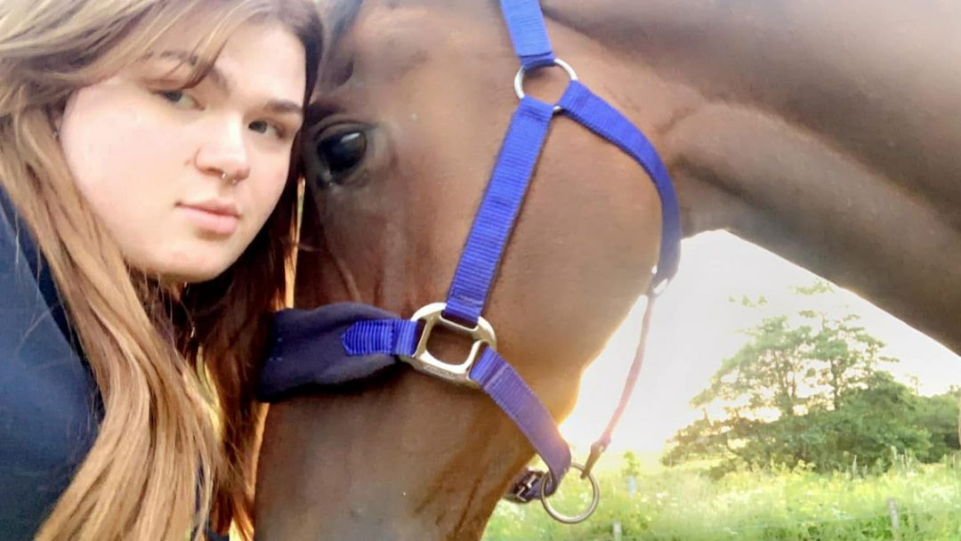 A close-up of a rider hugging a horse